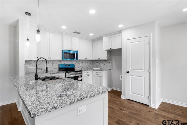 kitchen featuring light stone countertops, appliances with stainless steel finishes, a sink, a peninsula, and baseboards
