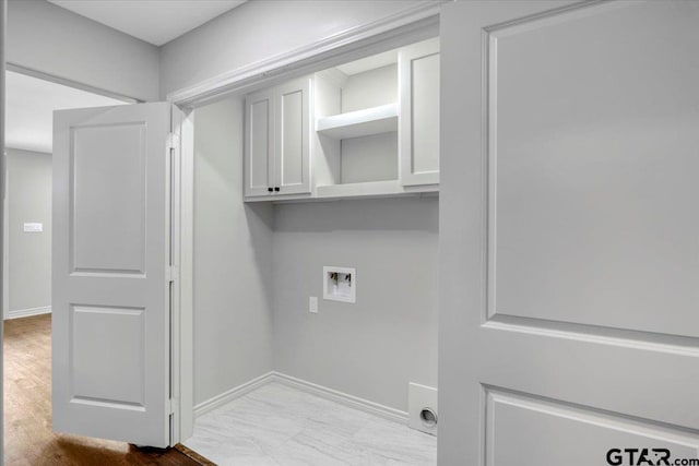 laundry area featuring washer hookup, baseboards, and cabinet space