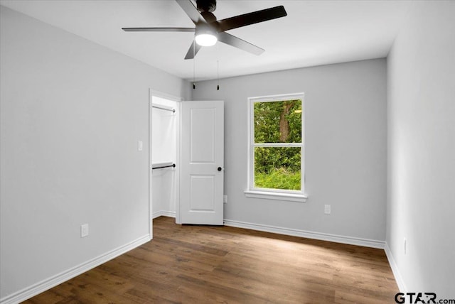 empty room featuring baseboards, ceiling fan, and wood finished floors