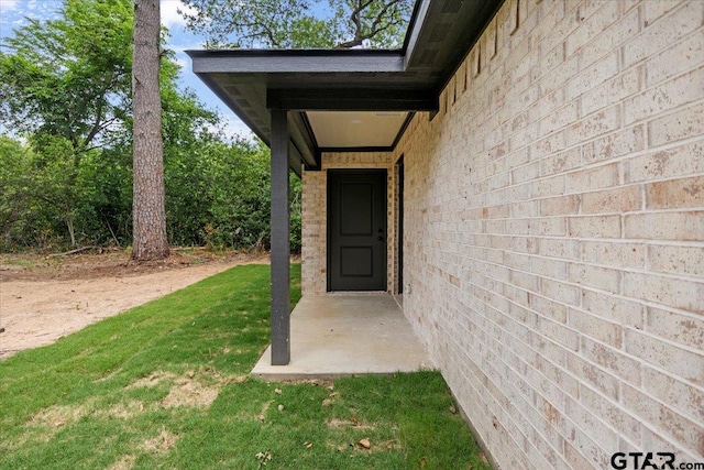 doorway to property with a lawn
