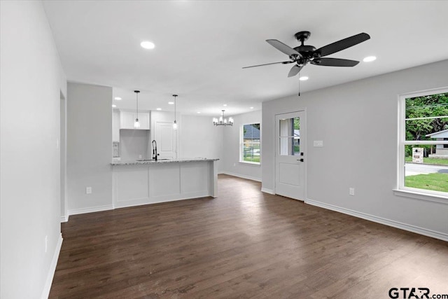 unfurnished living room featuring recessed lighting, baseboards, and dark wood-style floors