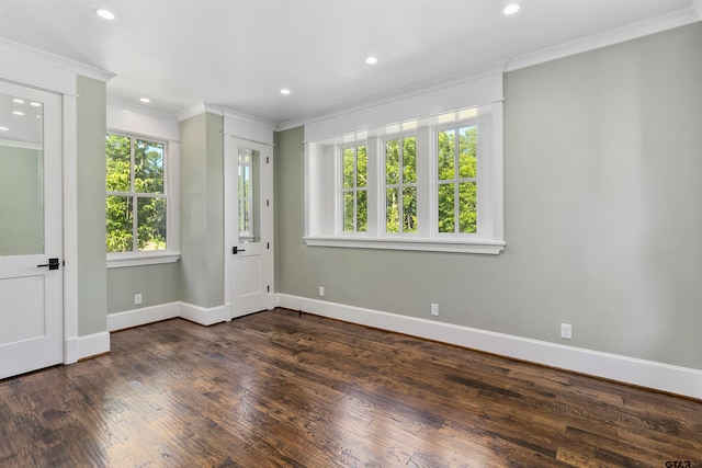 empty room with dark hardwood / wood-style floors and crown molding