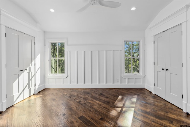 unfurnished bedroom with multiple windows, lofted ceiling, ceiling fan, and dark hardwood / wood-style floors