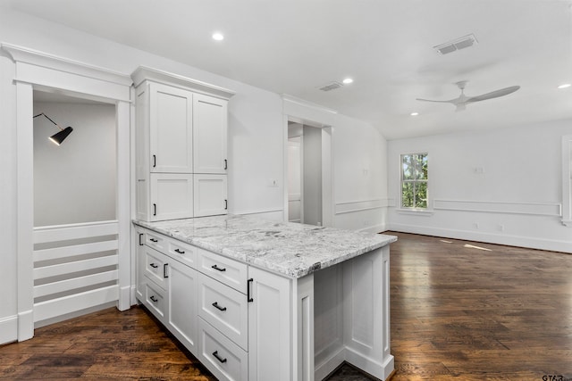 kitchen featuring white cabinets, ceiling fan, dark hardwood / wood-style flooring, and light stone counters