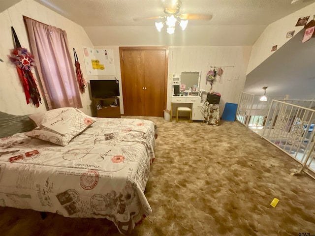 bedroom with lofted ceiling, ceiling fan, a textured ceiling, and carpet floors