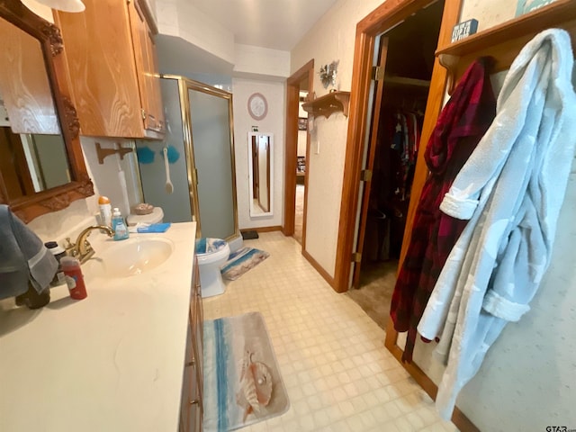 bathroom featuring vanity, toilet, and an enclosed shower