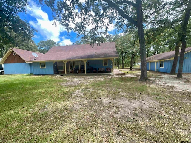 back of property with a lawn and a patio area