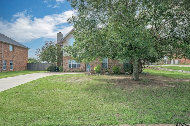 obstructed view of property with a front lawn