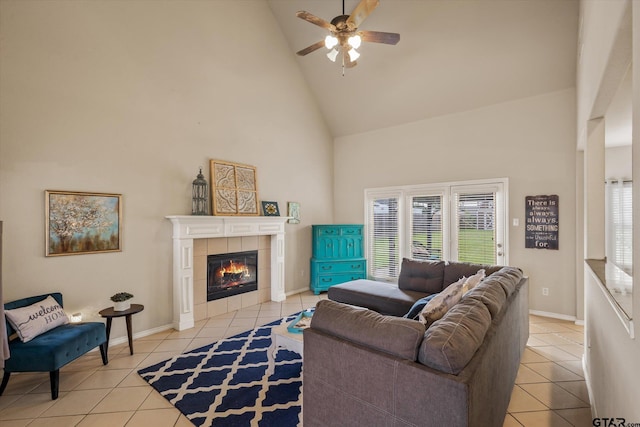 living room with a tile fireplace, light tile patterned floors, high vaulted ceiling, and a healthy amount of sunlight