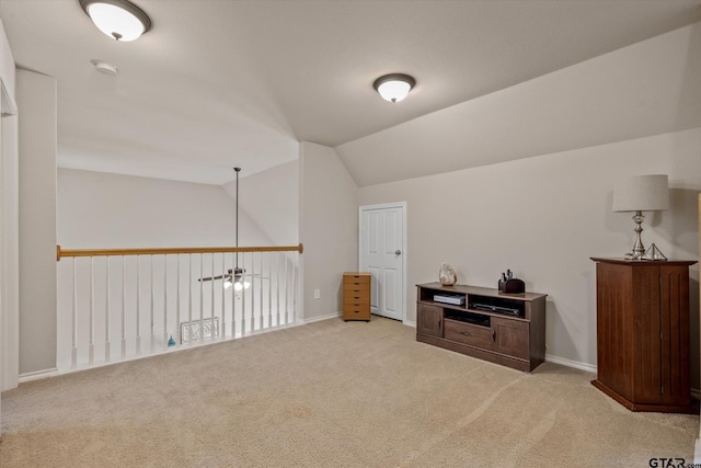 additional living space featuring light colored carpet and vaulted ceiling