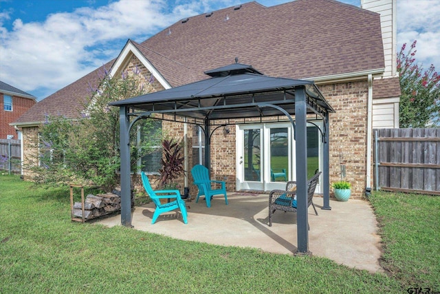 rear view of house with a gazebo, a patio area, and a yard