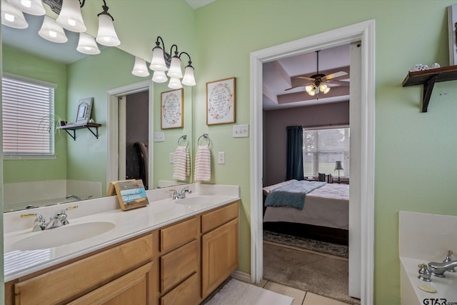 bathroom featuring tile patterned floors, a wealth of natural light, a bath, and ceiling fan with notable chandelier