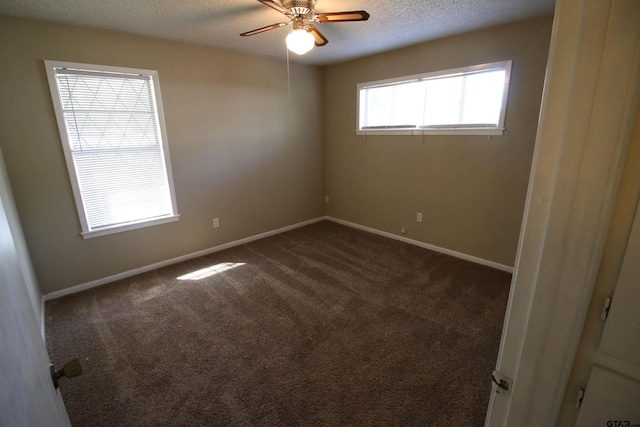 spare room with ceiling fan, a textured ceiling, and dark colored carpet