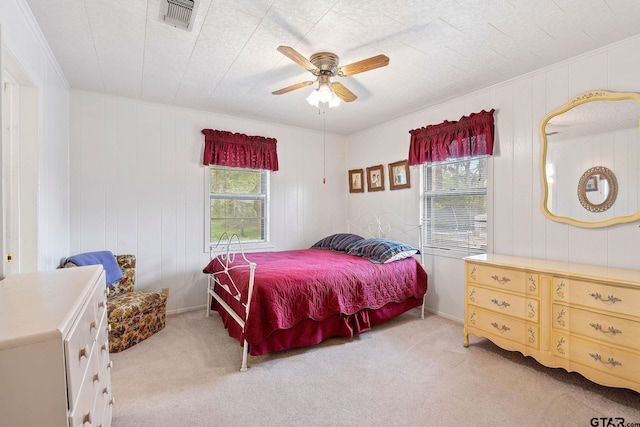 bedroom featuring ceiling fan, ornamental molding, and light carpet