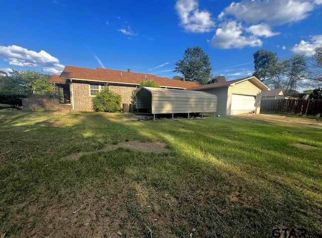 rear view of property featuring a garage, a lawn, and a carport