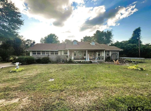 ranch-style house featuring a front lawn and covered porch