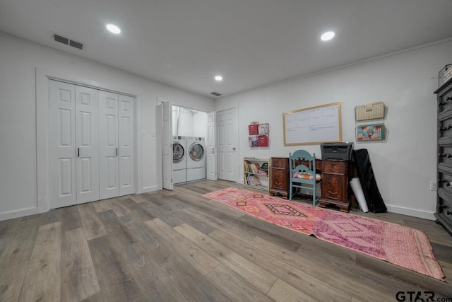 interior space with recessed lighting, visible vents, washer and dryer, and wood finished floors