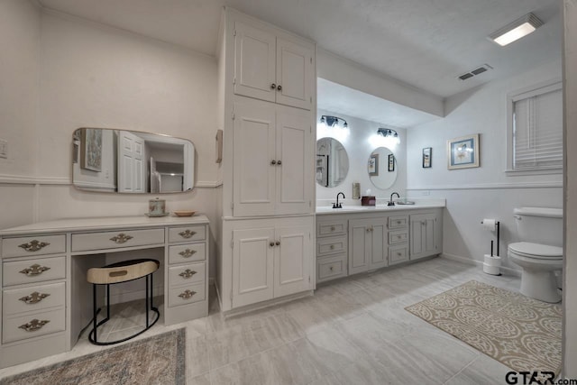 full bath with double vanity, toilet, visible vents, and a sink