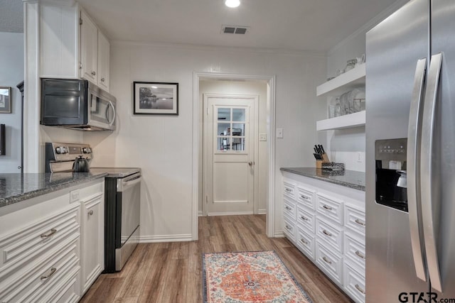 kitchen with stainless steel appliances, visible vents, dark wood-style flooring, and white cabinetry