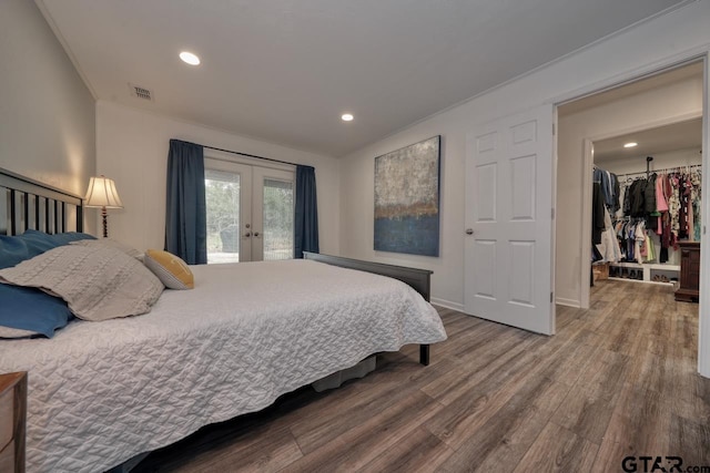 bedroom with wood finished floors, visible vents, recessed lighting, french doors, and access to outside