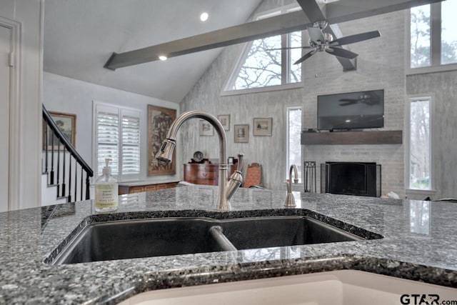 kitchen with plenty of natural light, dark stone countertops, and a brick fireplace