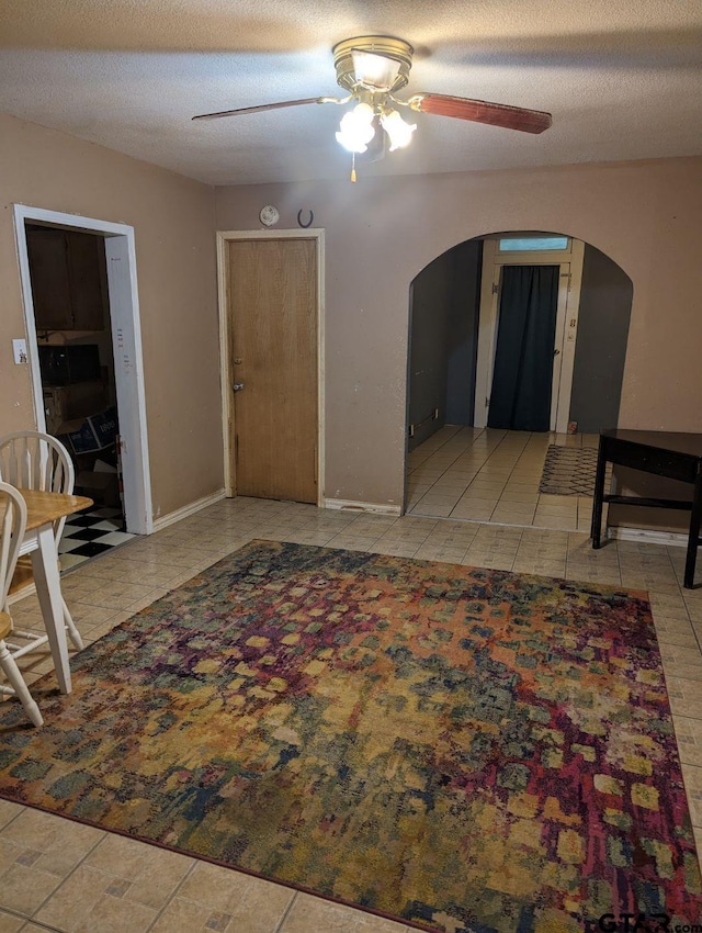 interior space with a textured ceiling and ceiling fan