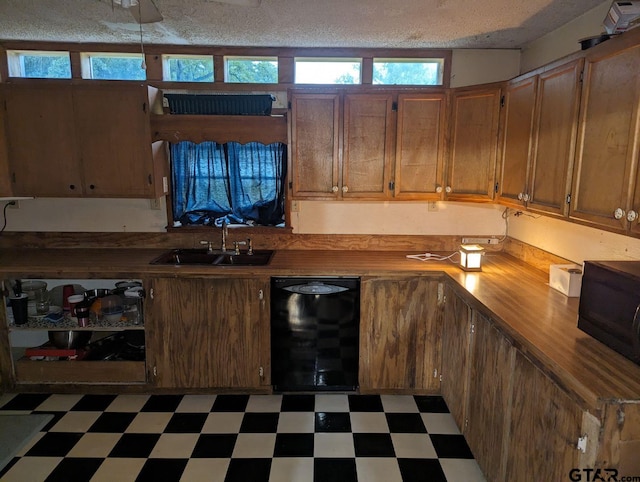 kitchen with dishwasher, wooden counters, sink, and a textured ceiling