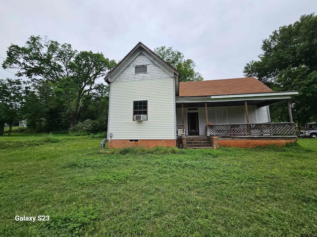 view of front of property with a front lawn, cooling unit, and covered porch