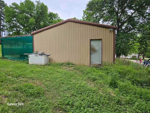 view of outbuilding featuring a lawn