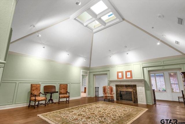 612 Rosemont Pl, Ii Place, Tyler, TX 75701 - living room featuring a decorative wall, a premium fireplace, dark wood-type flooring, vaulted ceiling, and a skylight