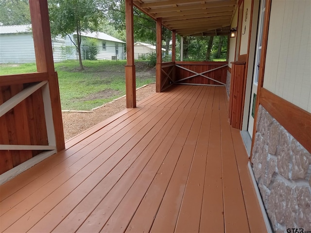 wooden terrace featuring a lawn