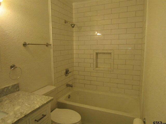 full bathroom with vanity, toilet, and tiled shower / bath combo