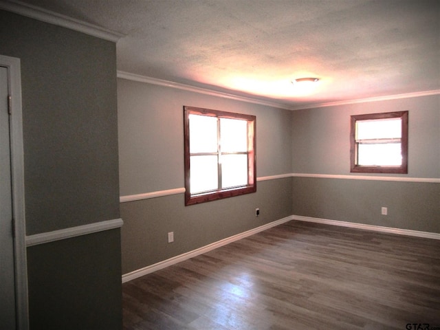 spare room with a wealth of natural light, dark wood-type flooring, and crown molding