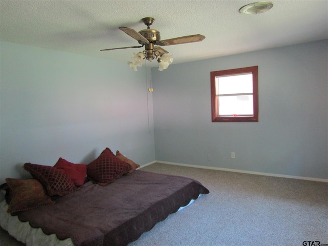 bedroom with carpet flooring, a textured ceiling, and ceiling fan