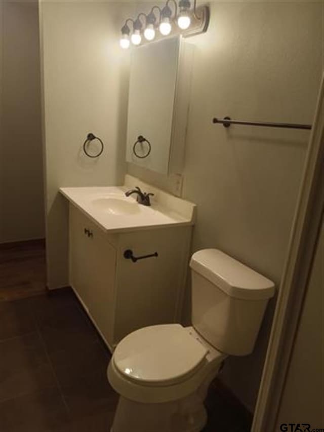 bathroom featuring tile patterned flooring, vanity, and toilet