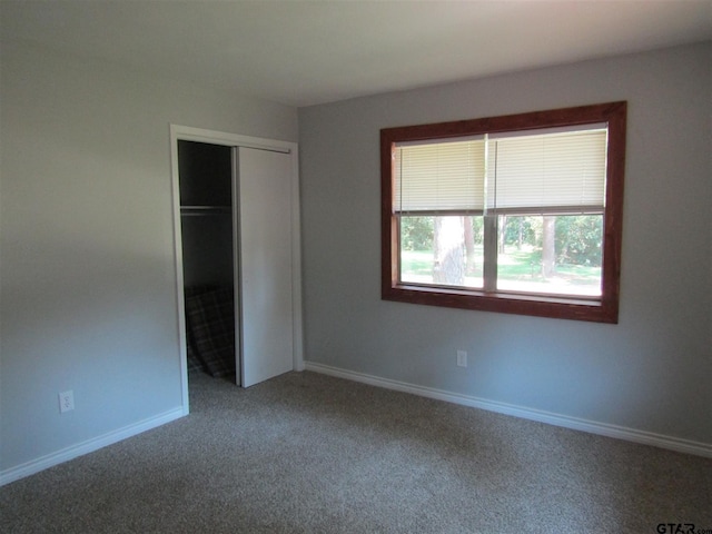 unfurnished bedroom with a closet and carpet