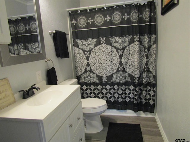 bathroom with toilet, vanity, hardwood / wood-style floors, and curtained shower