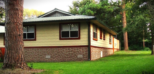 view of side of home featuring a lawn