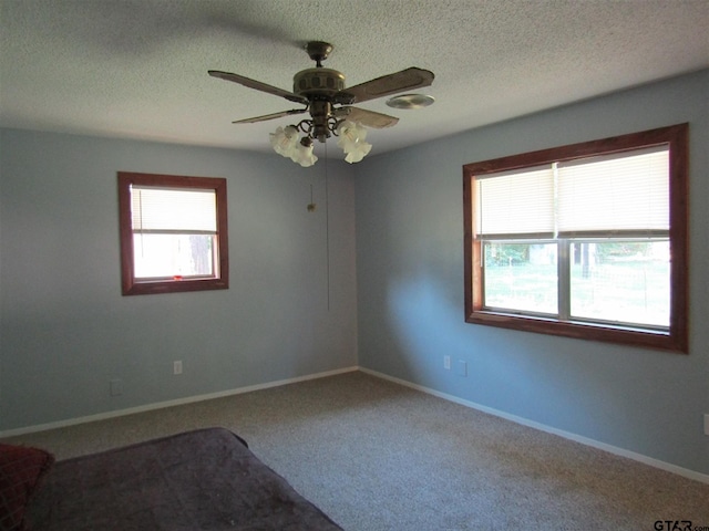 carpeted empty room featuring a textured ceiling and ceiling fan