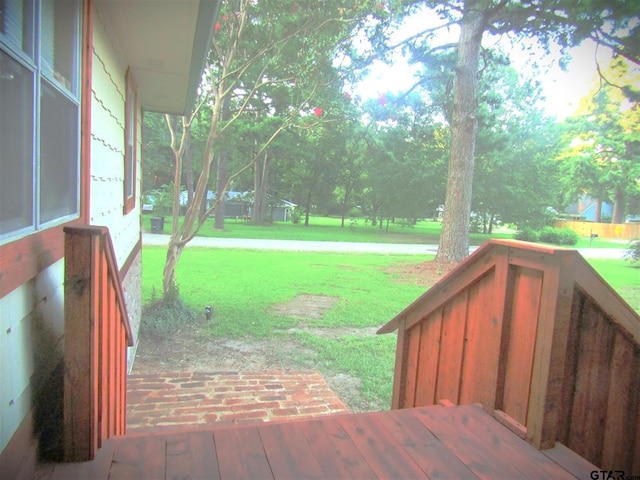 wooden terrace featuring a yard