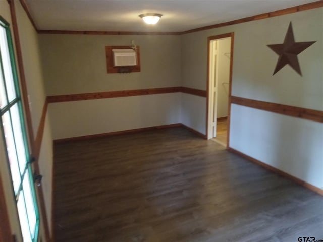 spare room featuring dark wood-type flooring and ornamental molding