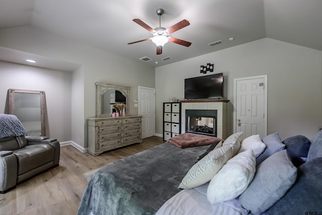 21327 Altuda Ln, Flint, TX 75762 - bedroom with vaulted ceiling, light wood finished floors, a tile fireplace, and a ceiling fan