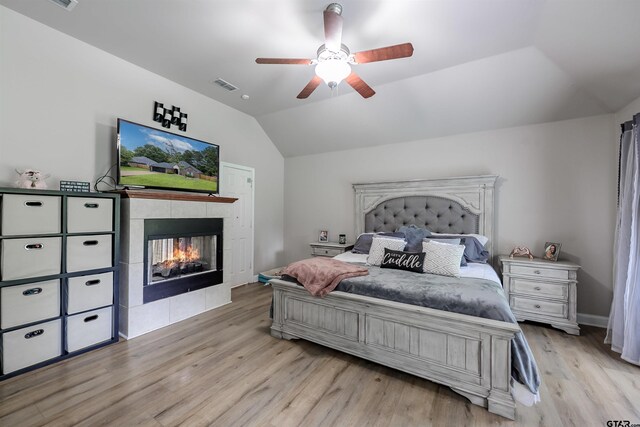 21327 Altuda Ln, Flint, TX 75762 - bedroom with lofted ceiling, a tiled fireplace, wood finished floors, and ceiling fan
