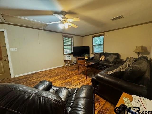 living room featuring dark hardwood / wood-style flooring, ceiling fan, and ornamental molding