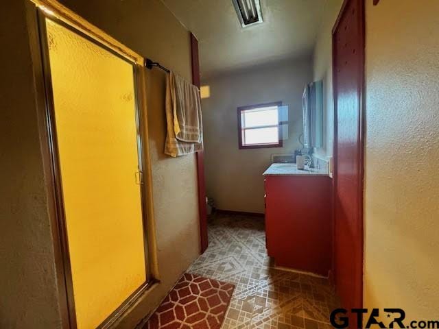 bathroom with tile patterned flooring, vanity, and an enclosed shower