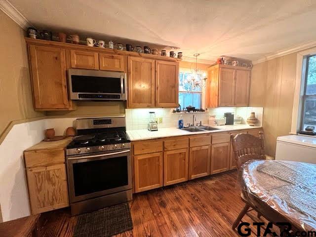 kitchen featuring crown molding, dark wood-type flooring, and appliances with stainless steel finishes