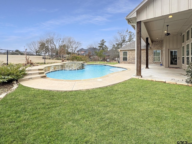 view of pool featuring pool water feature, ceiling fan, a yard, and a patio area