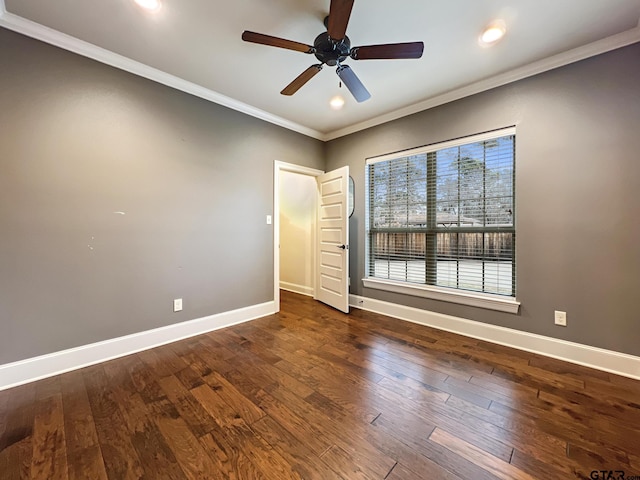 spare room with crown molding, ceiling fan, and dark wood-type flooring