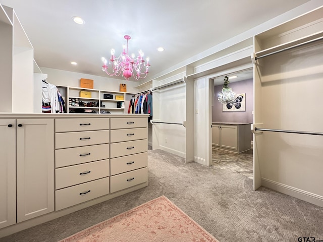 spacious closet with light colored carpet and a chandelier