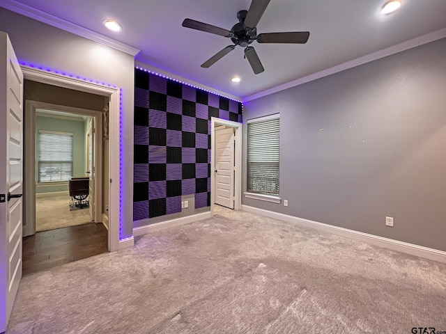 unfurnished bedroom featuring ceiling fan, ornamental molding, and carpet floors